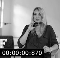 a woman talking on a cell phone in front of a white background